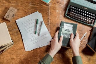 Máquina de escrever, manuscritos e mãos segurando um livro em uma composição sobre literatura e escrita.